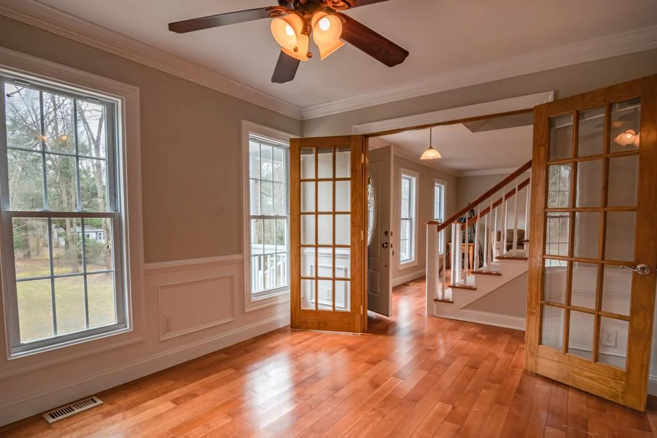 Industrial vacuum cleaner placed on dirty parquet in room with green walls and doorway in spacious apartment during repair works